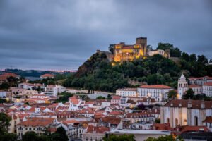 Vista panorâmica do Castelo de Leiria num monte verde, um marco histórico para quem pensa morar em Leiria.